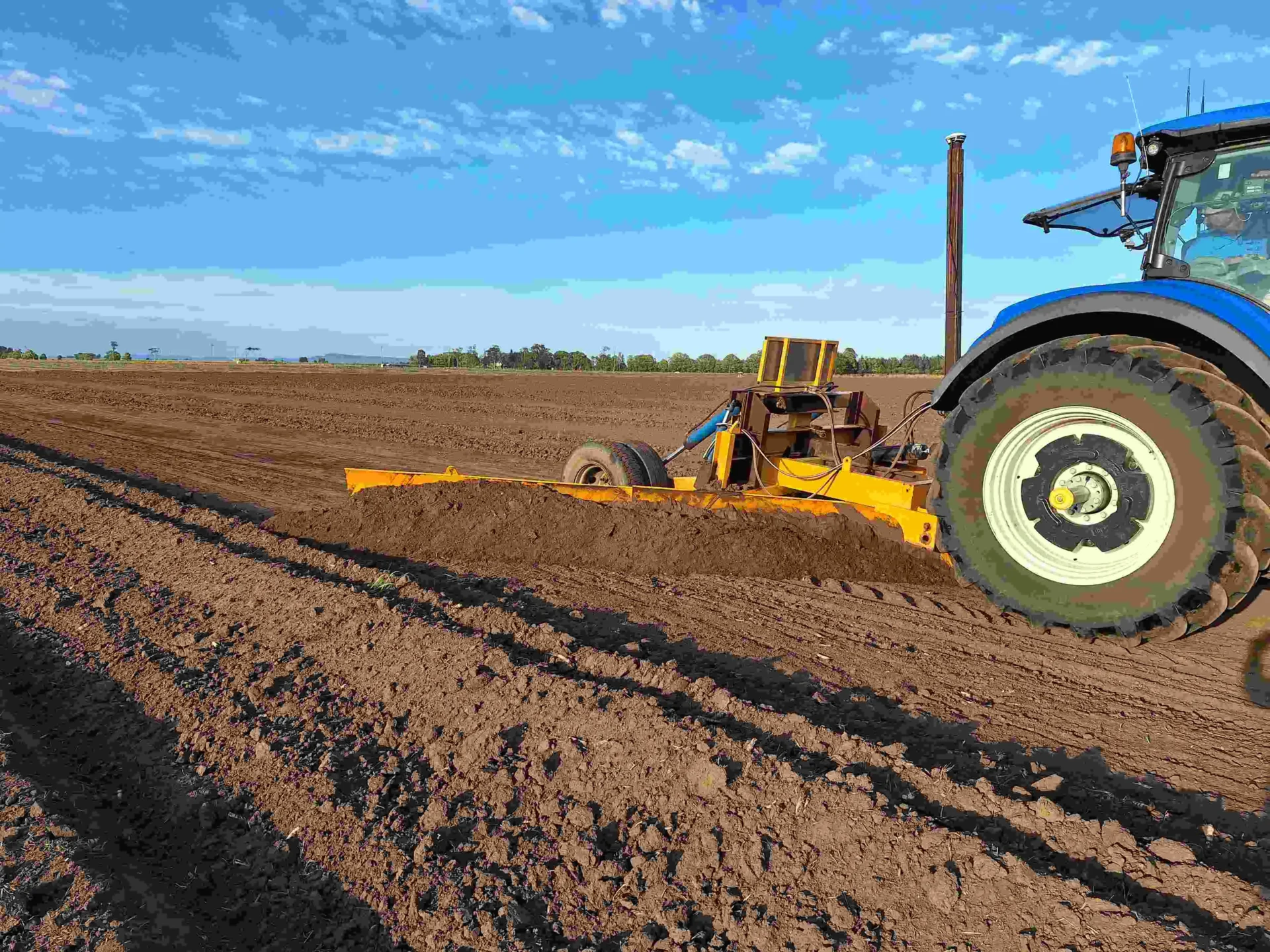 A tractor is pulling a plow across the field.